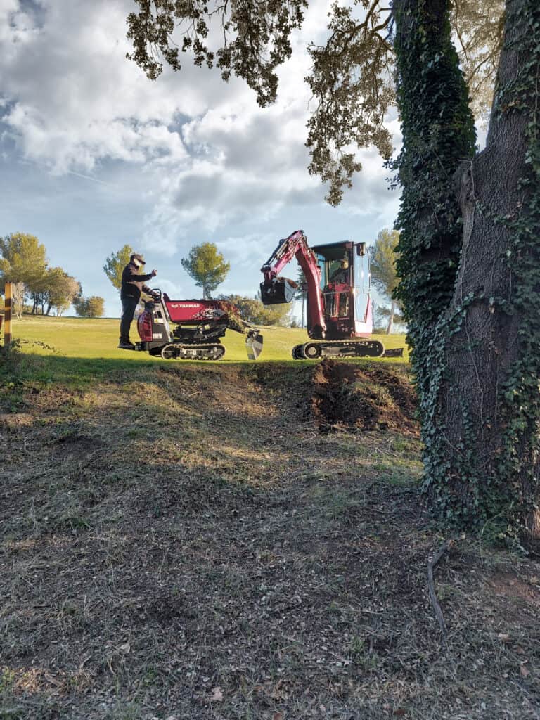 Compacte mini graafmachine en operator bij werkzaamheden in de tuin, werkzaamheden voor landschapsinrichting.